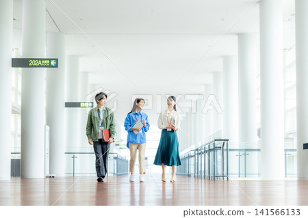Male and female business team walking down an office corridor 141566133