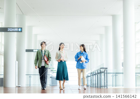 Male and female business team walking down an office corridor Male and female business team walking down an office corridor 141566142