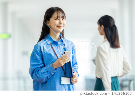 經營一部智能手機的女商人在辦公室 141566163