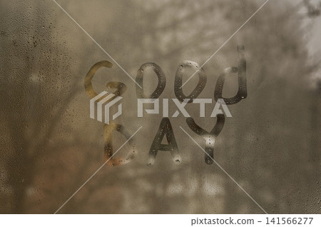 Inscription Good Day is handwritten on fogged window glass with water drops. Inscription Good Day is handwritten on fogged window glass with water drops. 141566277