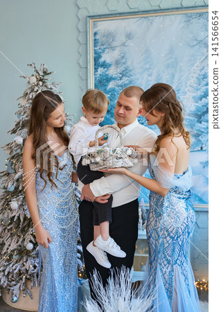 medium shot photograph of a family gathered together in a light-blue studio decorated with frosted medium shot photograph of a family gathered together in a light-blue studio decorated with frosted 141566654