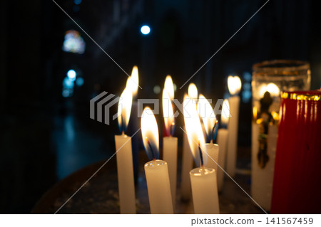 Candles lit in a church, creating a serene atmosphere 141567459