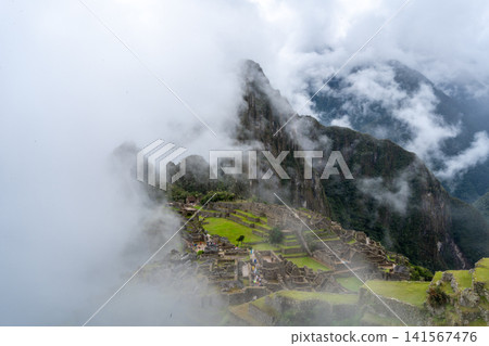 Panoramic view of Machu Picchu ruins surrounded by misty mountains, Peru Panoramic view of Machu Picchu ruins surrounded by misty mountains, Peru 141567476