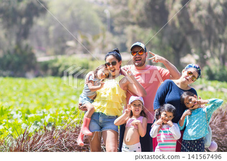 Happy diverse family making funny faces in outdoor green field Happy diverse family making funny faces in outdoor green field 141567496