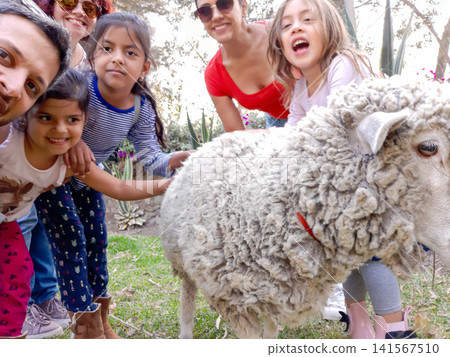 Large family posing for selfie with pet sheep outdoors Large family posing for selfie with pet sheep outdoors 141567510