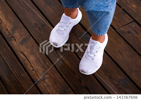 Clean white sneakers became dirty after rain and dirt. Bad weather at summer cause shoes damage. Image for footwear protection devices and attachments Clean white sneakers became dirty after rain and dirt. Bad weather at summer cause shoes damage. Image for footwear protection devices and attachments 141567606