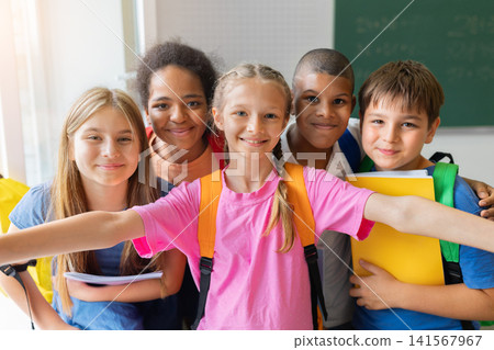 Diverse schoolchildren gathering closely for cheerful group selfie in the classroom Diverse schoolchildren gathering closely for cheerful group selfie in the classroom 141567967