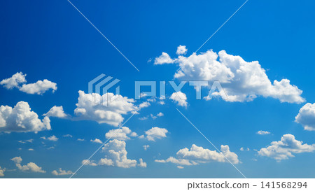 multiple white cumulus clouds across spacious blue sky 141568294