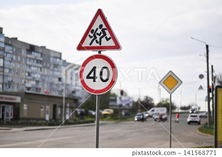 Triangular road sign warns drivers about children crossing near school. Triangular road sign warns drivers about children crossing near school. 141568771
