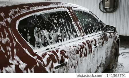 car covered in foam during wash, soap bubbles coating entire side of vehicle. car covered in foam during wash, soap bubbles coating entire side of vehicle. 141568791