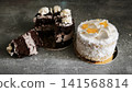 Delicious chocolate cake and sweet coconut treat placed on dark counter. 141568814