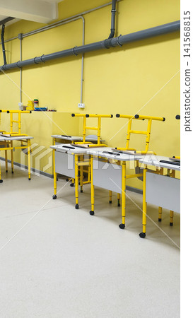 workshop interior with work tables and tools setup in bright yellow room. workshop interior with work tables and tools setup in bright yellow room. 141568815