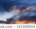 Cloud formation glowing above horizon during colorful sunset with dramatic atmosphere. 141569054