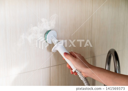 Cleaning the white sink and faucet in the bathroom with a steam generator. Releases steam. Combats mold and calcium. Cleaning the white sink and faucet in the bathroom with a steam generator. Releases steam. Combats mold and calcium. 141569373