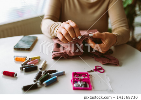 repairing an old pullover 141569730