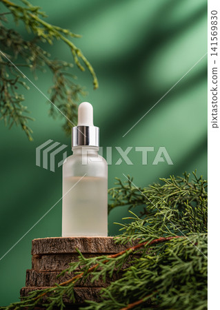 Glass cosmetic serum bottle on natural background with green leaves Glass cosmetic serum bottle on natural background with green leaves 141569830