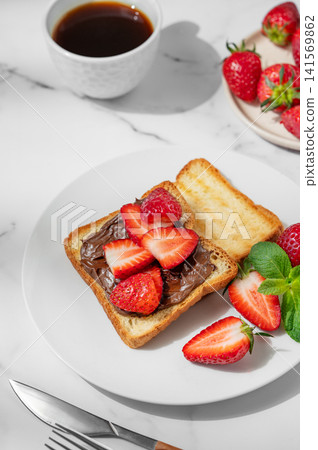 Toasted bread with chocolate cream and strawberry on a plate on a marble background 141569862