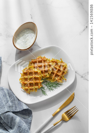 Vegetarian potato waffles with natural yogurt and dill on a plate on a marble background 141569886