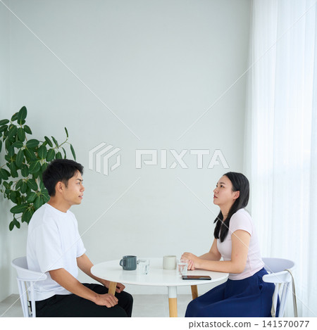 A man and a woman talking face to face in a cafe. A man and a woman talking face to face in a cafe. 141570077