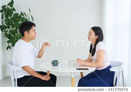 A man and a woman talking face to face in a cafe. A man and a woman talking face to face in a cafe. 141570078
