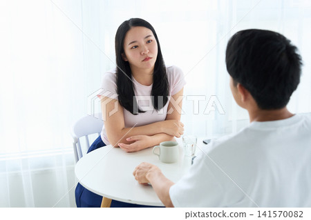 A man and a woman talking face to face in a cafe. A man and a woman talking face to face in a cafe. 141570082