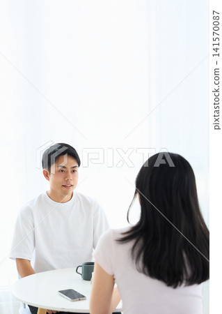 一男一女在咖啡館裡面對面交談。 141570087