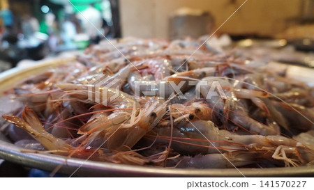 Platter of raw shrimp clustered in fresh market display Platter of raw shrimp clustered in fresh market display 141570227