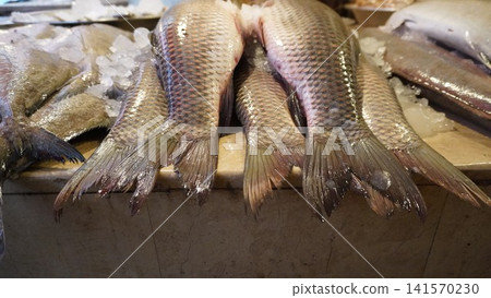 Neatly arranged fish tails on marble surface with ice Neatly arranged fish tails on marble surface with ice 141570230