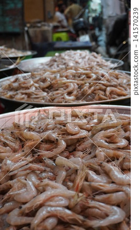 Low angle shot of platters piled with raw shrimp Low angle shot of platters piled with raw shrimp 141570239