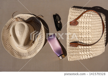 Top View of Summer Beach Kit Straw Hat Woven Tote Sunglasses and Cream Tube Top View of Summer Beach Kit Straw Hat Woven Tote Sunglasses and Cream Tube 141570328