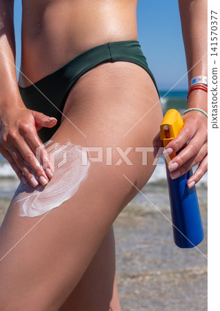 Close Up of Woman in Bikini Rubbing Sunscreen Lotion on Her Thigh Close Up of Woman in Bikini Rubbing Sunscreen Lotion on Her Thigh 141570377