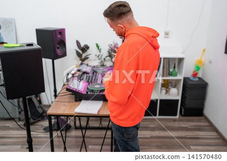Man and woman in music studio reviewing DJ mixing notes and working with soundboards. DJ, music studio, notes, soundboard, review Man and woman in music studio reviewing DJ mixing notes and working with soundboards. DJ, music studio, notes, soundboard, review 141570480