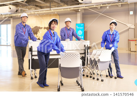 工作人員搬運折疊桌椅,在室內佈置場地。 工作人員搬運折疊桌椅,在室內佈置場地。 141570546