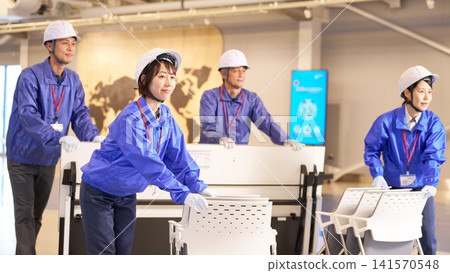 工作人員正在活動場地佈置桌椅。 141570548