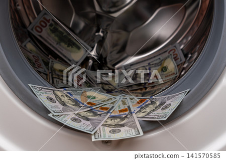 One hundred dollar bills inside open washing machine drum closeup One hundred dollar bills inside open washing machine drum closeup 141570585