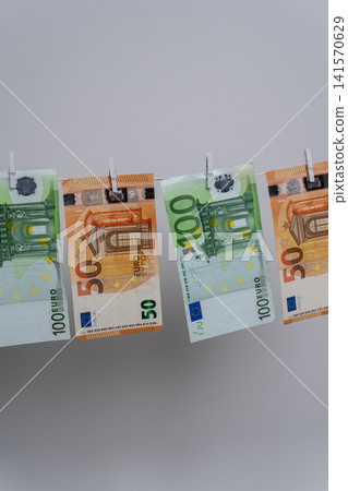 Four Euro Banknotes Hanging on Clothesline for Money Laundering Concept Four Euro Banknotes Hanging on Clothesline for Money Laundering Concept 141570629