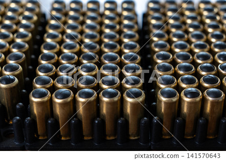 Rows of handgun ammunition with rubber bullets in plastic tray 141570643