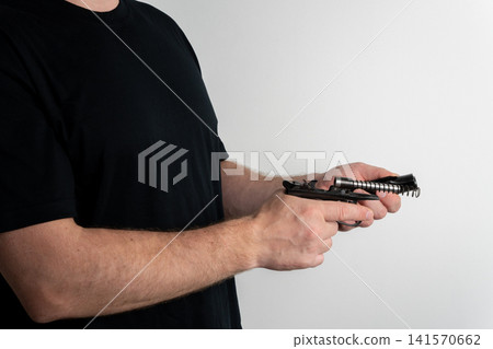 Man removing slide from semi automatic pistol during disassembly Man removing slide from semi automatic pistol during disassembly 141570662