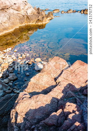 peaceful rock reflection in the sea water. calm summer vacation at the black sea. sunny weather peaceful rock reflection in the sea water. calm summer vacation at the black sea. sunny weather 141570752