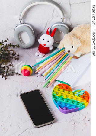 Social media ban concept for children. Smartphone and toys on the table, vertical view Social media ban concept for children. Smartphone and toys on the table, vertical view 141570852