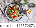A delicious salad of glass noodles, fried bell peppers, cilantro, and nuts on a plate on the table top view 141570873