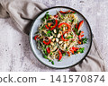 Close up of a delicious salad of glass noodles, fried bell peppers, cilantro, and nuts on a plate on the table top view 141570874