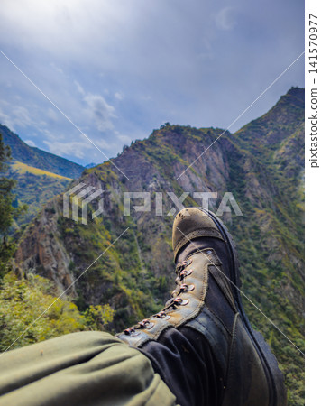 Hiking Boot Against Majestic Mountain Landscape Hiking Boot Against Majestic Mountain Landscape 141570977