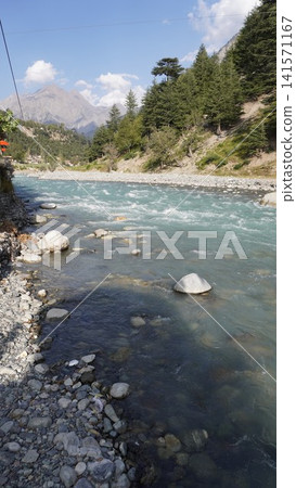 Turquoise mountain river flowing over smooth rocks with snow-capped mountains in background, glacial concept. Turquoise mountain river flowing over smooth rocks with snow-capped mountains in background, glacial concept. 141571167