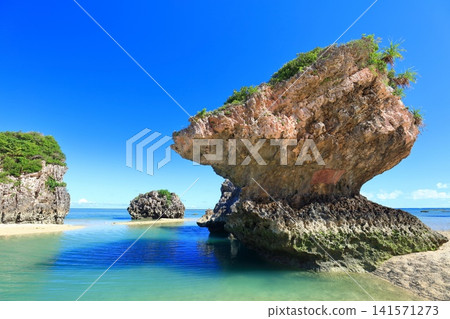 [Okinawa Prefecture] Mibaru Beach and rocky reef under a clear blue sky. 141571273