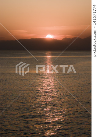 Sunset over the sea and sea candle seen from the Enoshima island Sunset over the sea and sea candle seen from the Enoshima island 141571774
