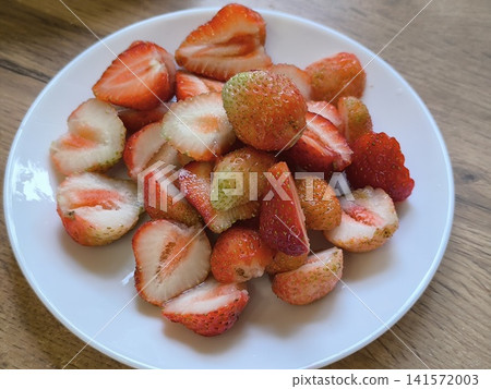 white plate filled with sliced and whole fresh strawberries white plate filled with sliced and whole fresh strawberries 141572003