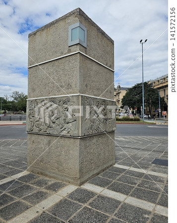 Cordoba, Argentina - April 11, 2026: Monumental Relief Pillar Beside Plaza Espana Cordoba, Argentina - April 11, 2026: Monumental Relief Pillar Beside Plaza Espana 141572156