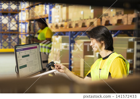 Logistics staff monitoring shipment details on package tracking interface, updating the delivery route details via airway bill numbers. Man typing parcel data on computer in the stock room. Logistics staff monitoring shipment details on package tracking interface, updating the delivery route details via airway bill numbers. Man typing parcel data on computer in the stock room. 141572433