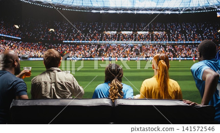 Close up of soccer fans watching live match broadcast at home creating realistic stadium feeling, drinking alcohol. Group of friends on apartment couch being transported to sports venue pitch Close up of soccer fans watching live match broadcast at home creating realistic stadium feeling, drinking alcohol. Group of friends on apartment couch being transported to sports venue pitch 141572546